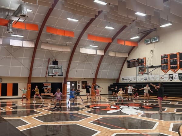 2026 summer campers practicing defensive stances across the gym floor