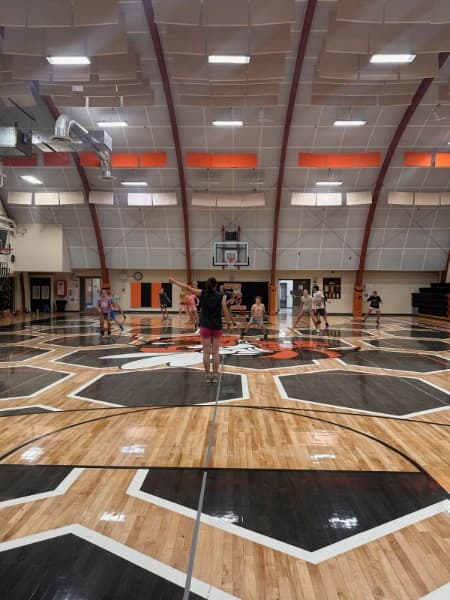 Coach leading a station while campers work through drills on the honeycomb court